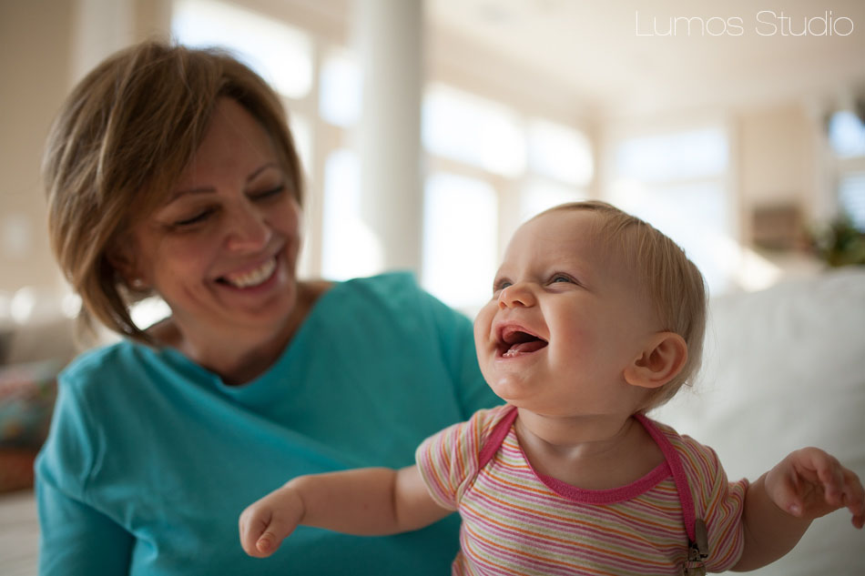 A cute baby laughs with her grandmother